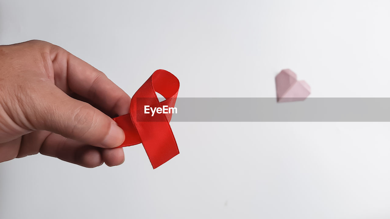 hand, red, pink, studio shot, finger, one person, indoors, emotion, close-up, holding, heart, positive emotion, adult, heart shape, copy space, love