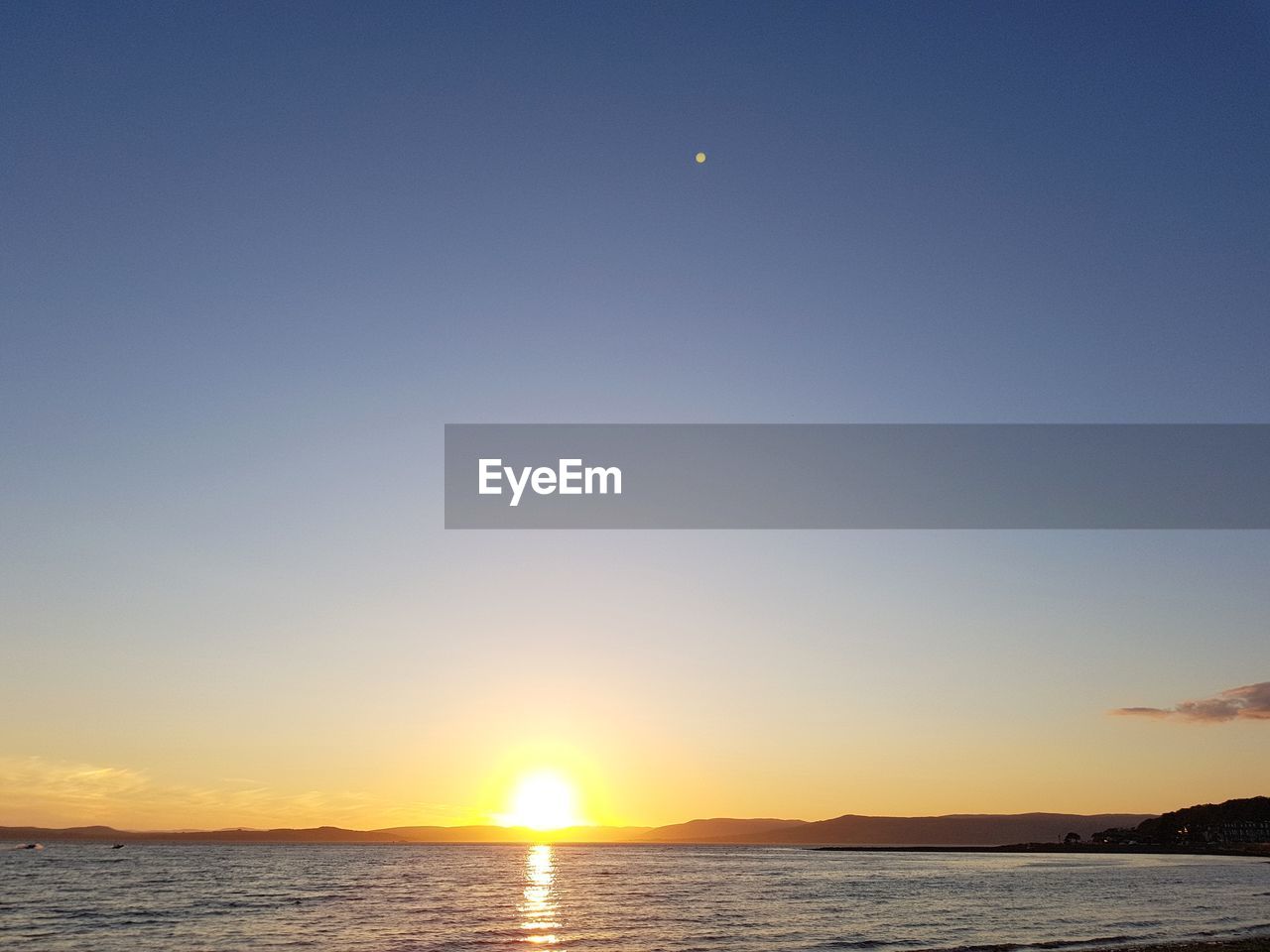 SCENIC VIEW OF SEA AGAINST CLEAR SKY AT SUNSET