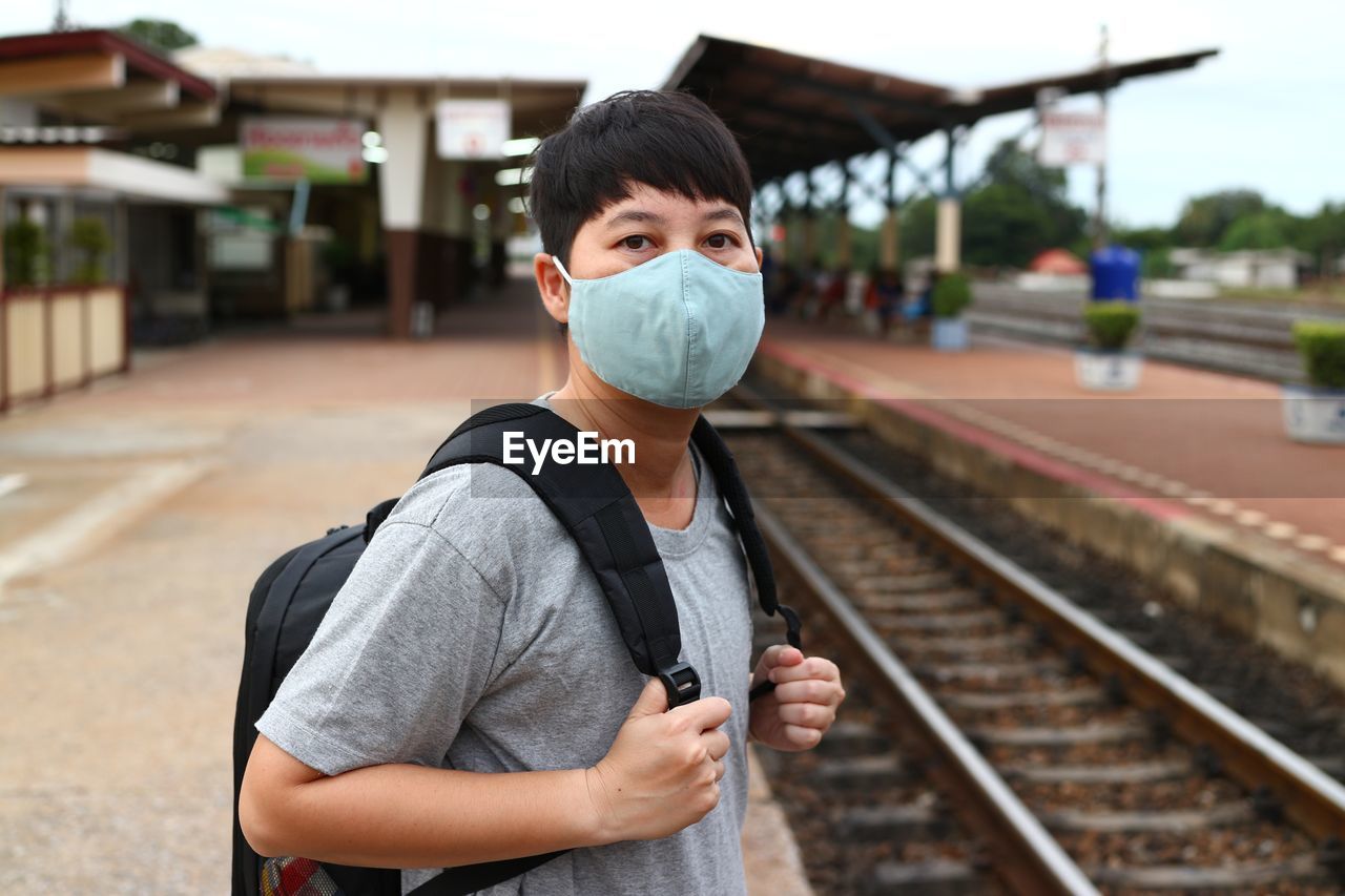 Portrait of man standing at railroad station