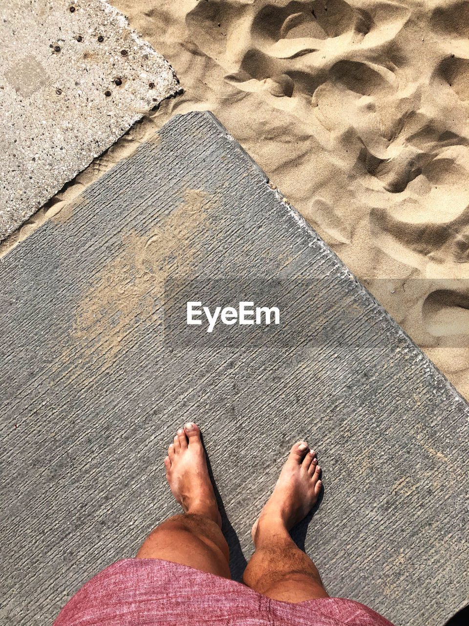 low section, human leg, sand, high angle view, beach, one person, personal perspective, land, lifestyles, leisure activity, barefoot, day, human foot, standing, nature, men, sunlight, adult, shoe, vacation, trip, relaxation, directly above, holiday, human limb, limb, outdoors, women, water, floor, casual clothing