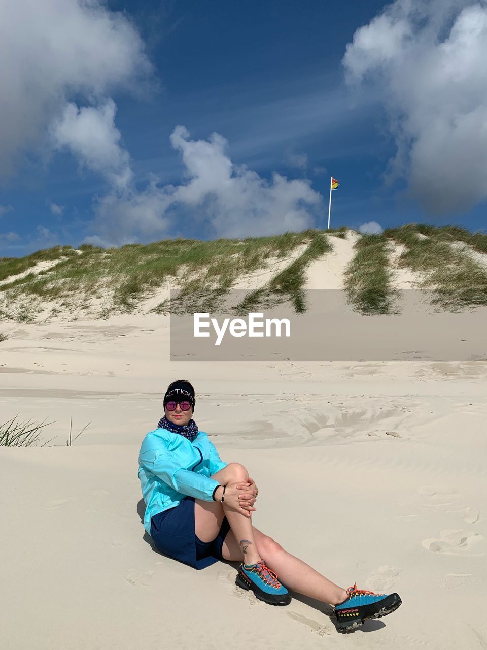 FULL LENGTH PORTRAIT OF YOUNG COUPLE SITTING ON LAND