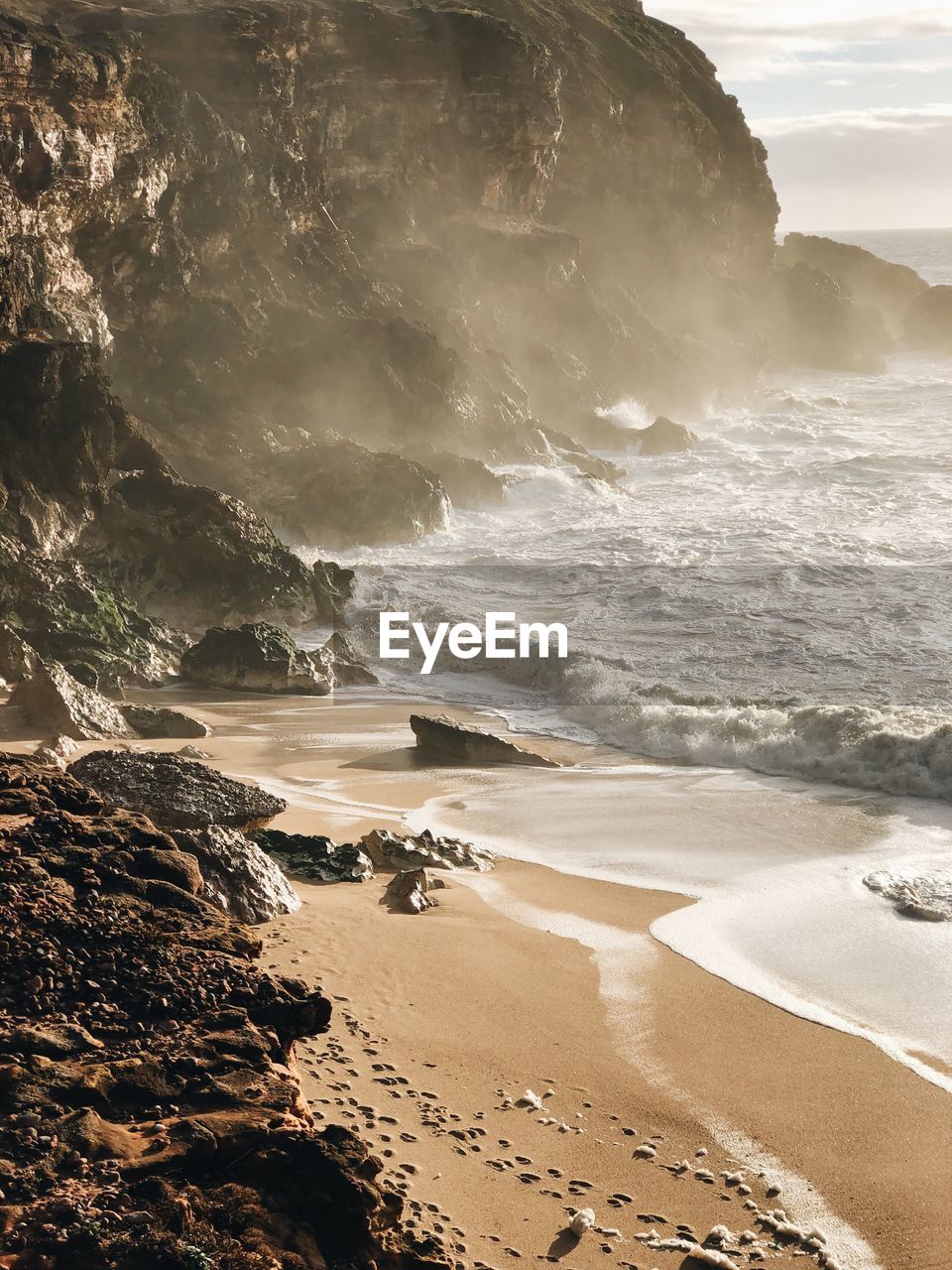 Scenic view of beach against rock formations