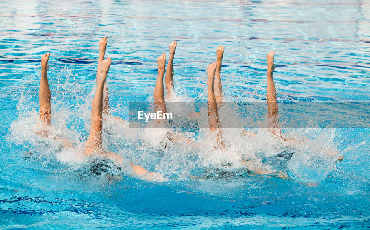 People performing synchronized swimming in pool