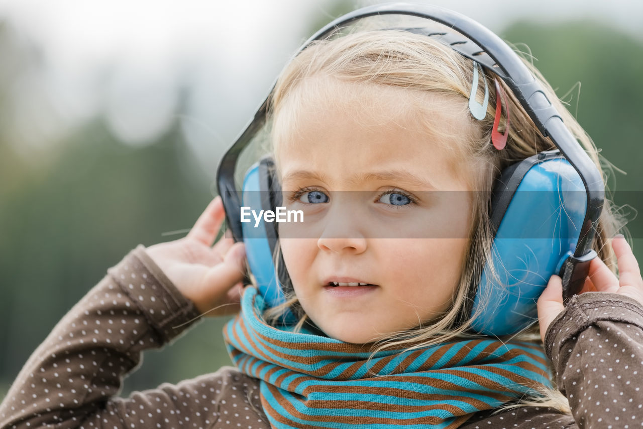 Close-up portrait of girl wearing ear protector