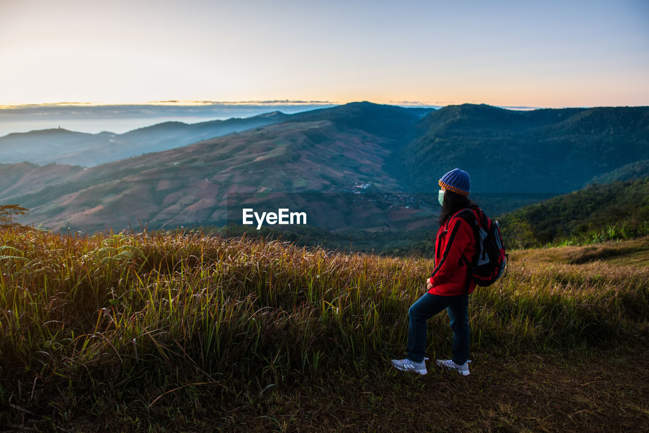 REAR VIEW OF WOMAN LOOKING AT MOUNTAIN