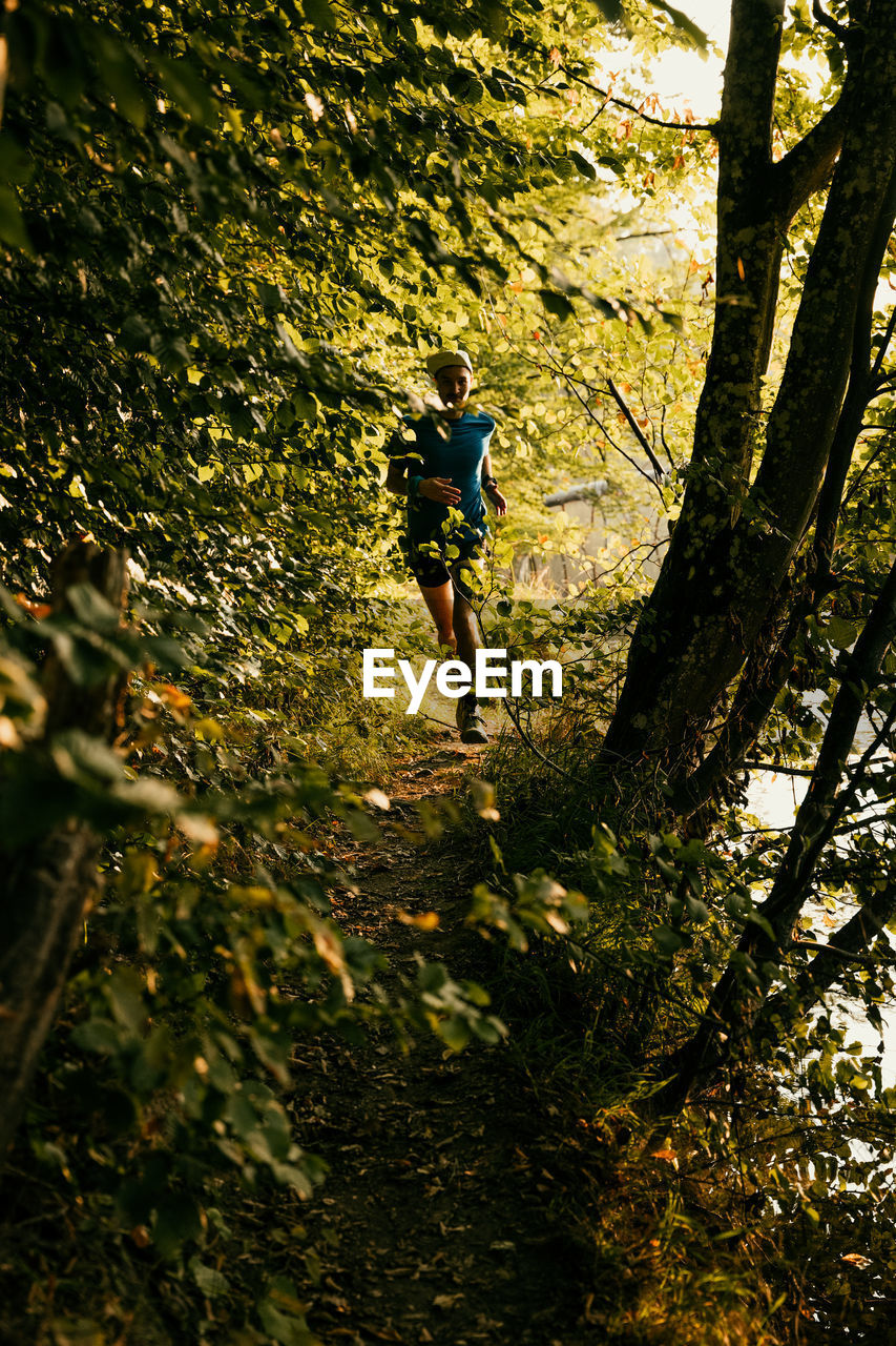 Full length of man running amidst plants