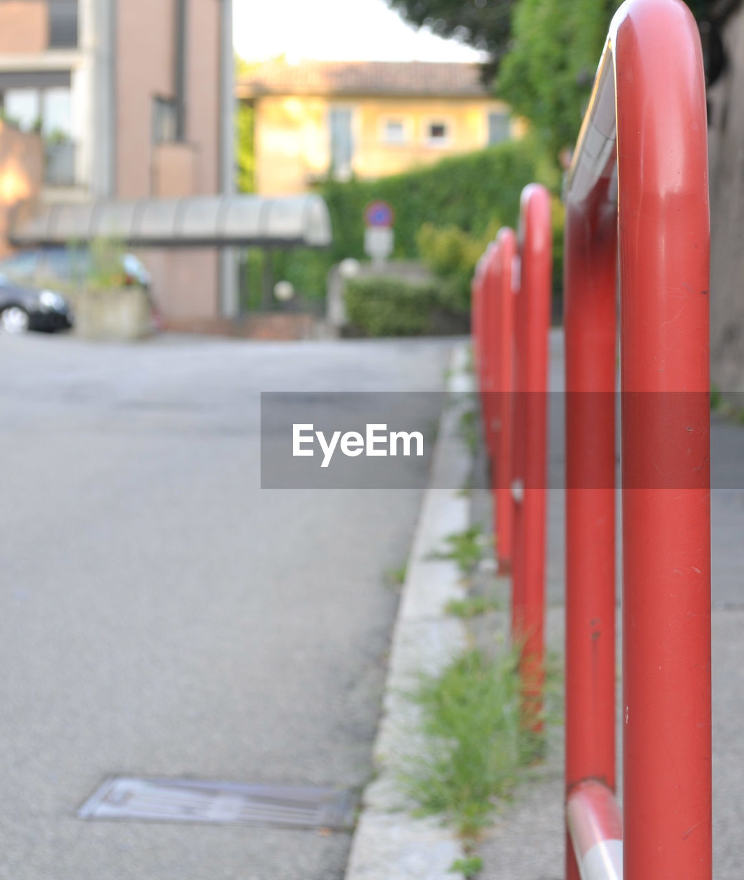 CLOSE-UP OF RED RAILING BY STREET