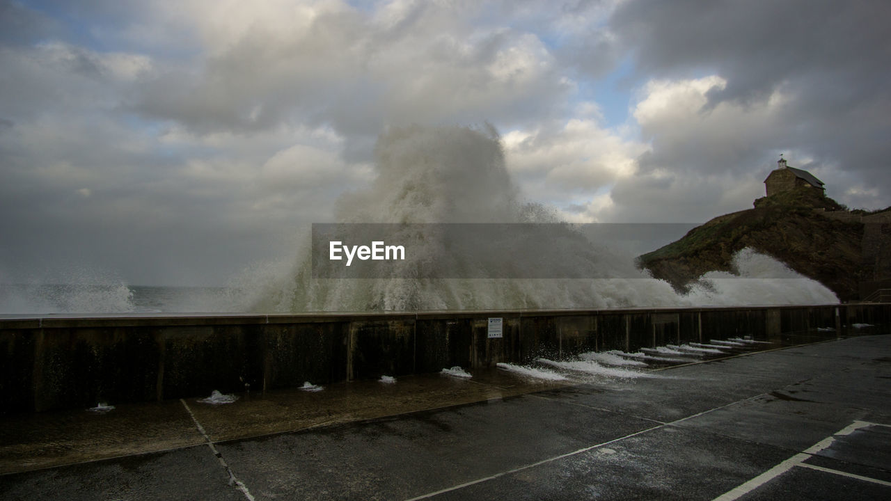 SCENIC VIEW OF WATERFALL AGAINST CLOUDY SKY
