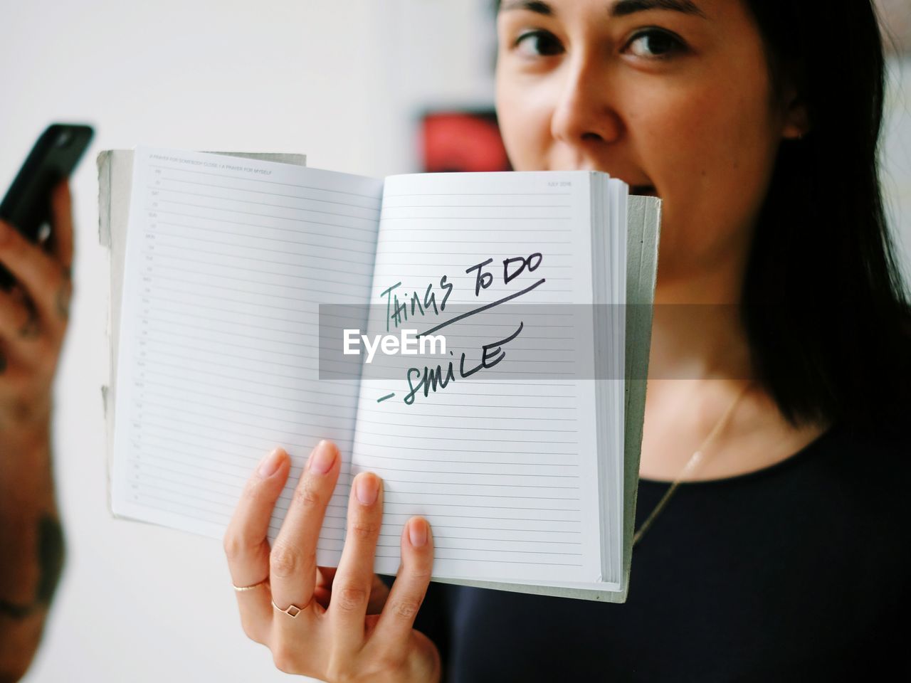 Portrait of young woman holding book with text