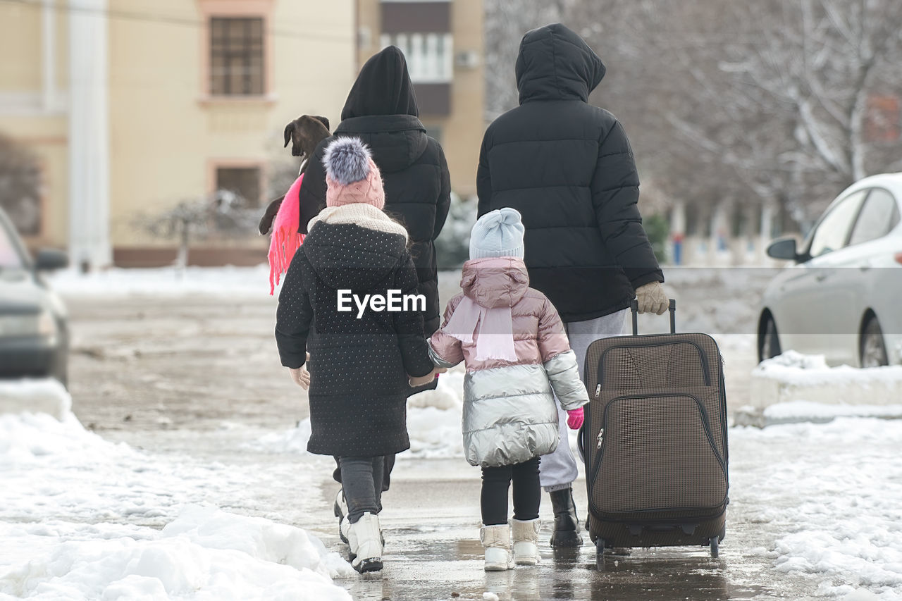 Rear view of people walking on snow