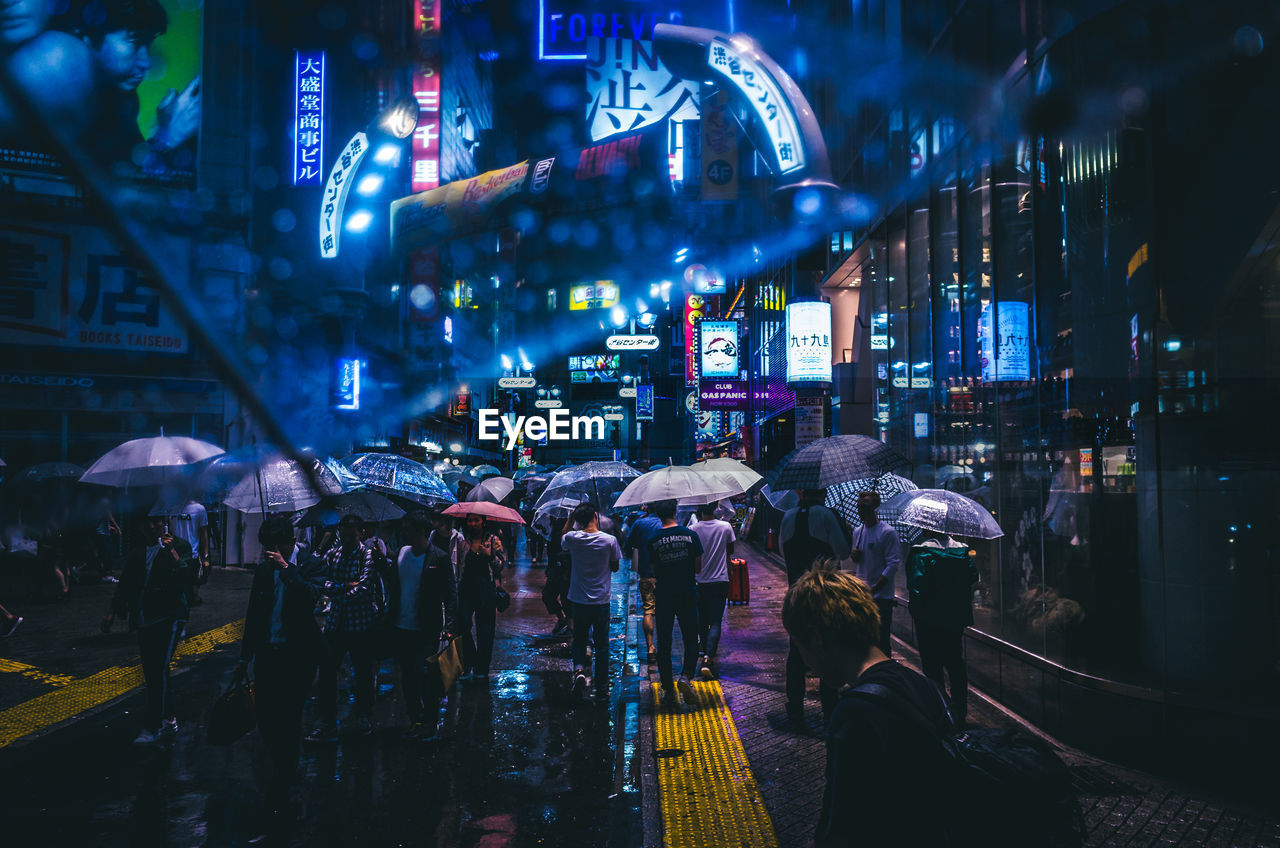 People in illuminated city at night