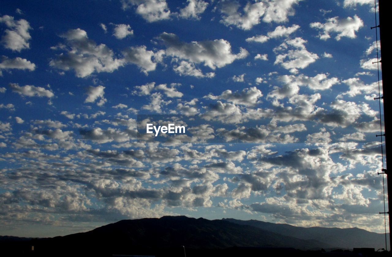 SCENIC VIEW OF MOUNTAINS AGAINST CLOUDY SKY
