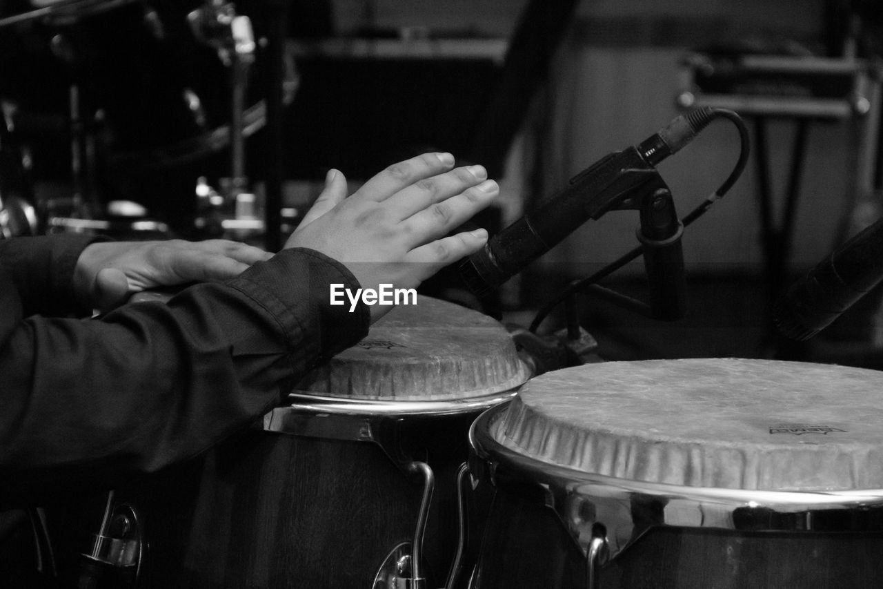 Cropped hands of musician playing drums
