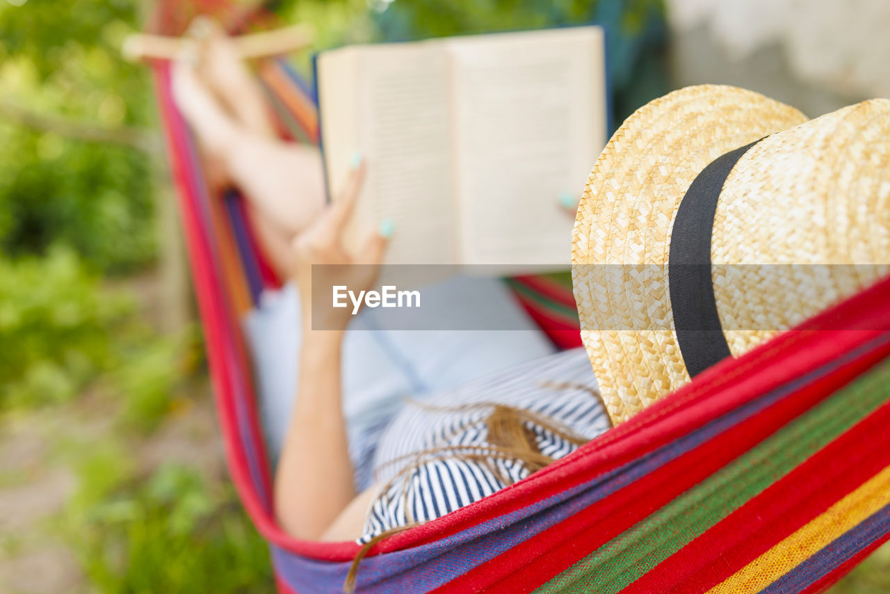 rear view of woman wearing hat while sitting on hammock