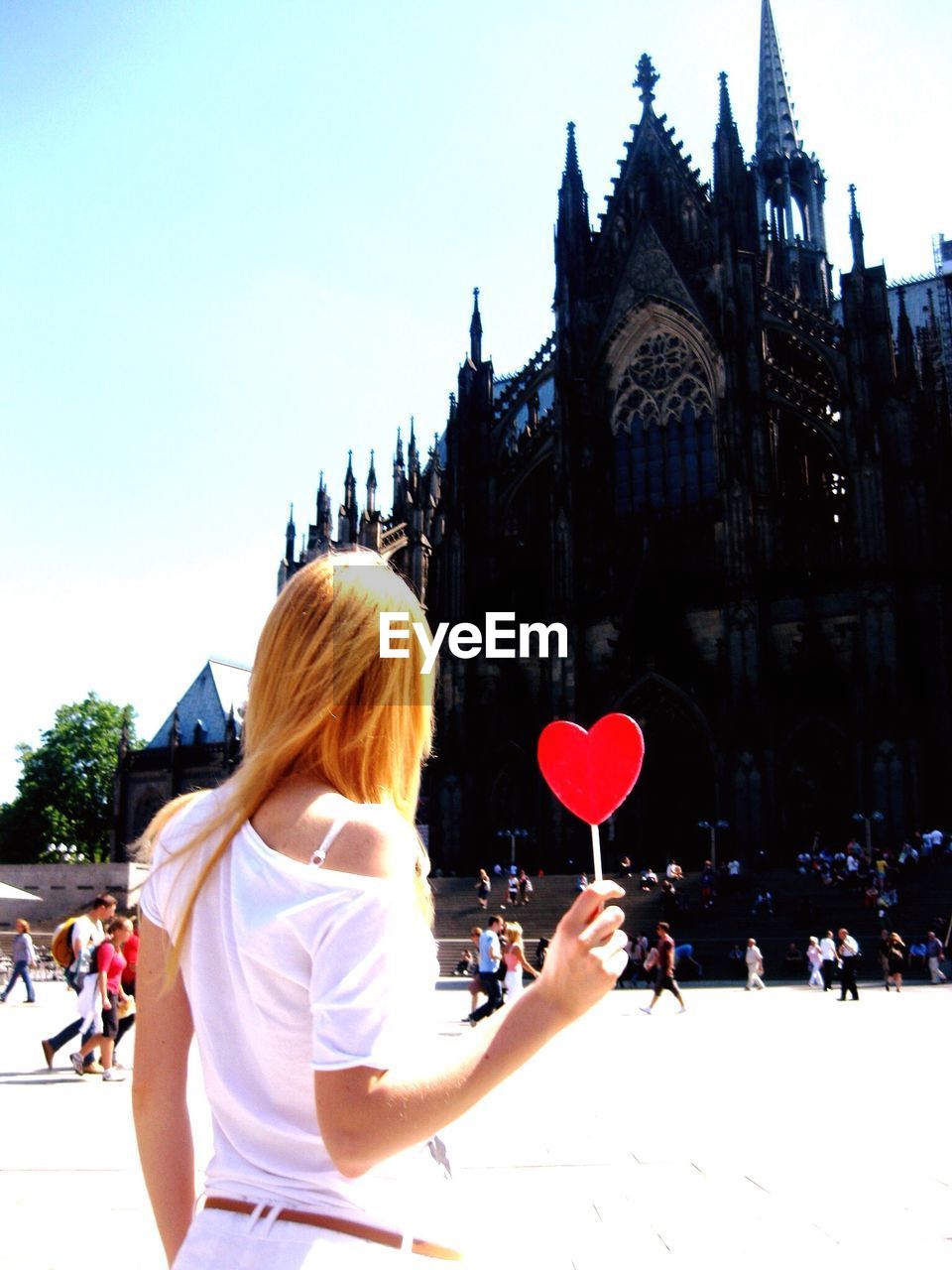 Rear view of woman standing with red heart shape at cologne cathedral