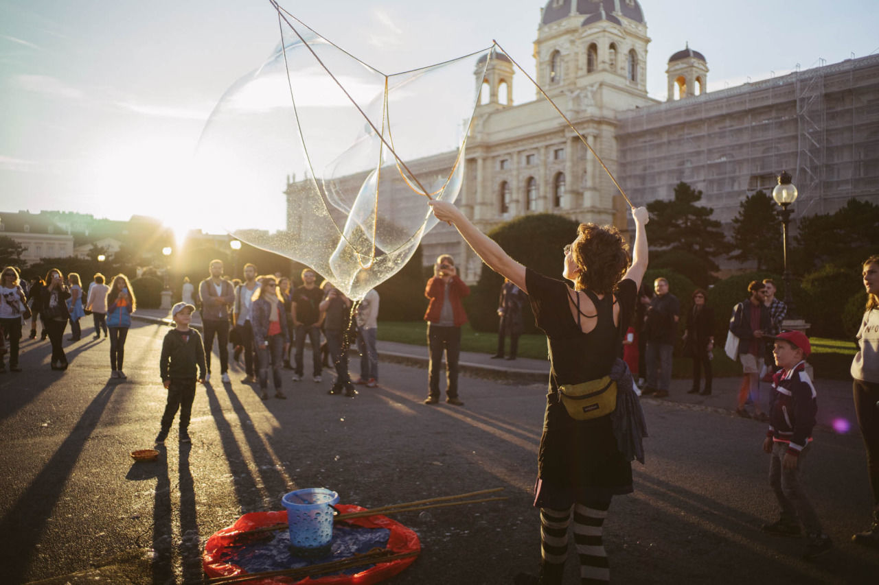 Street performer making soap bubble in front of crowd