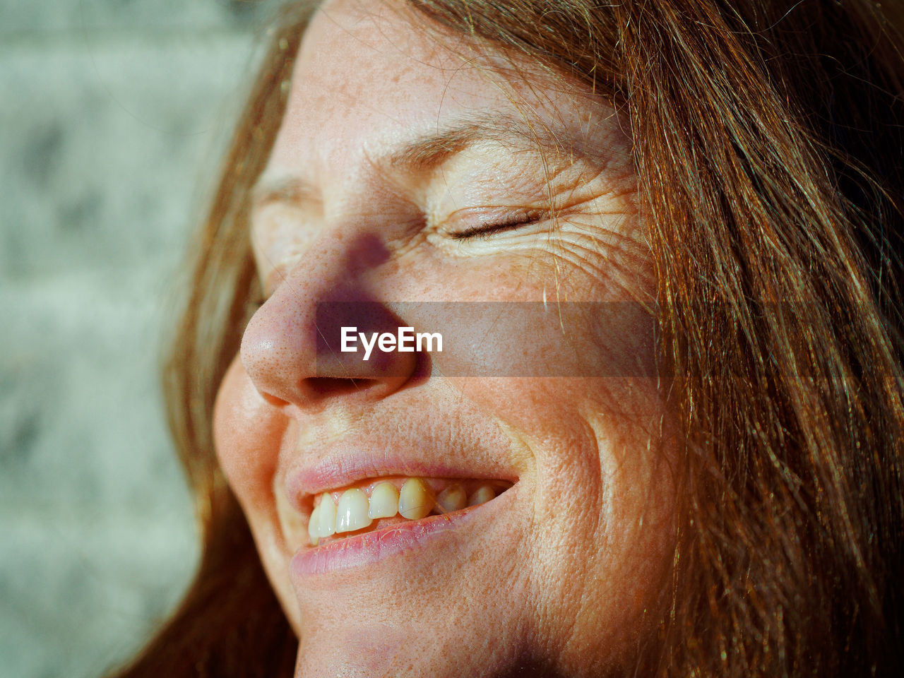 Close-up of smiling woman with closed eyes at home