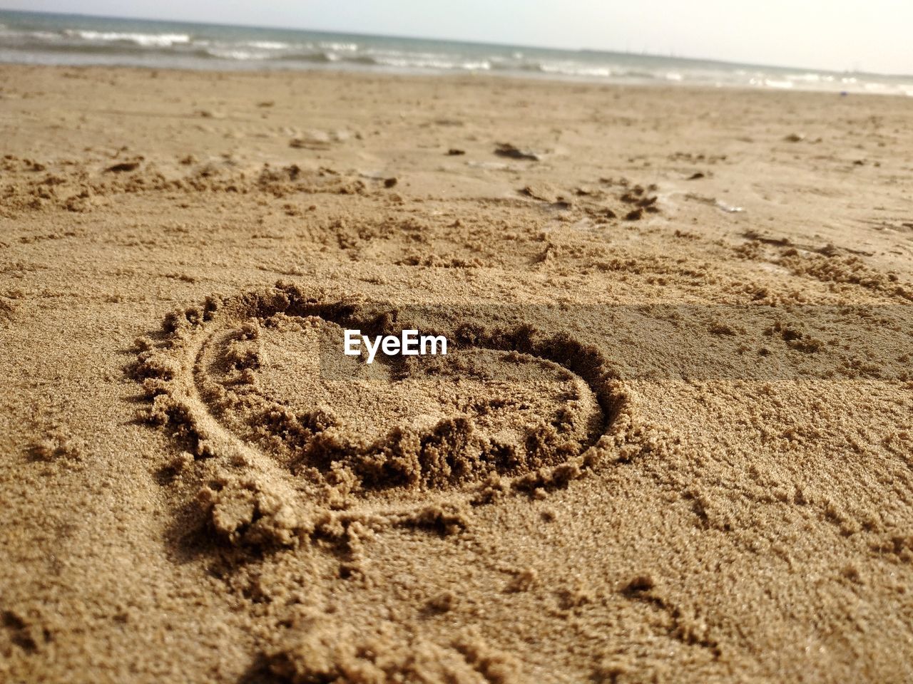 CLOSE-UP OF HEART SHAPE ON BEACH