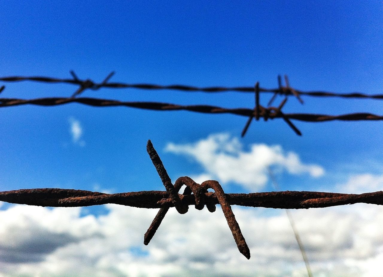 LOW ANGLE VIEW OF BARBED WIRE AGAINST SKY