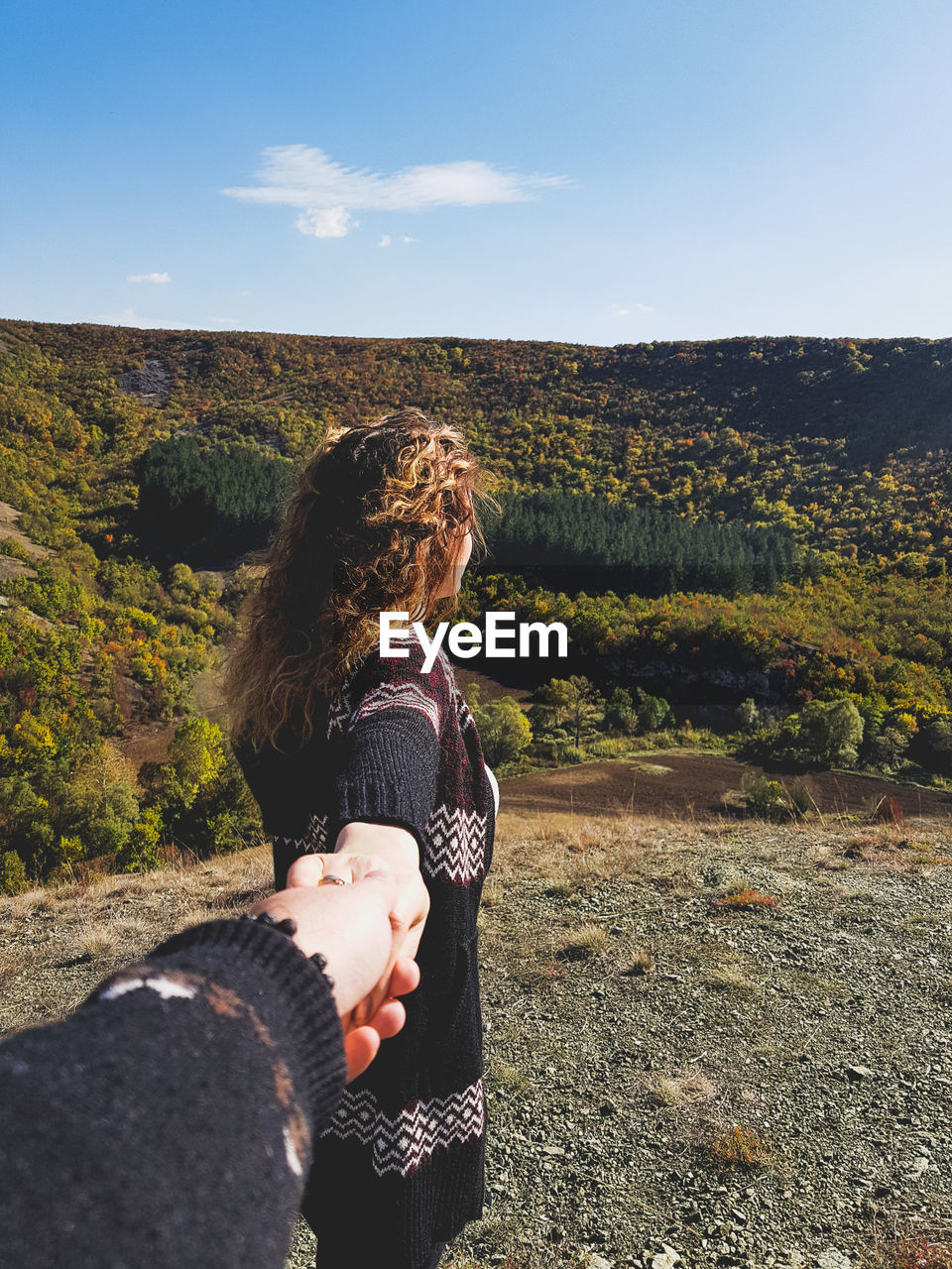 Cropped man holding hand of woman on field