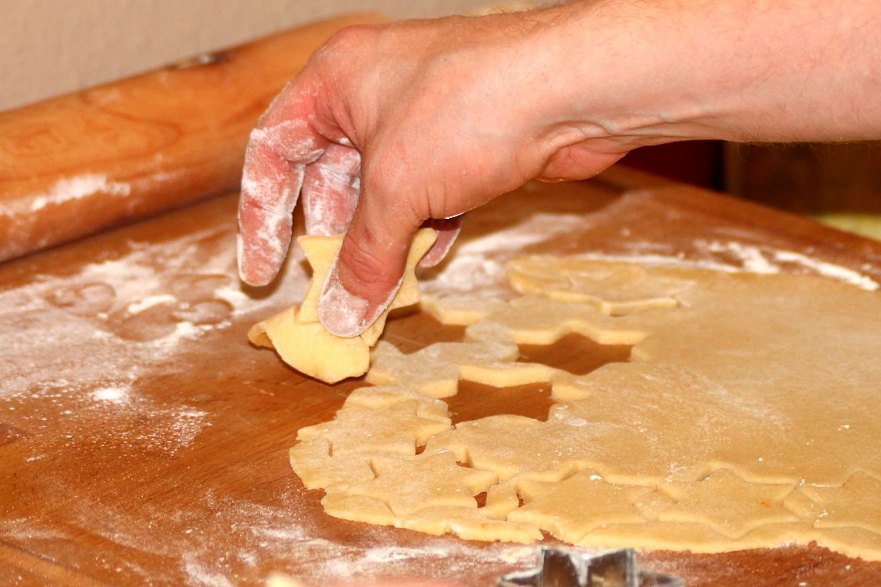 Cropped hand preparing christmas cookies