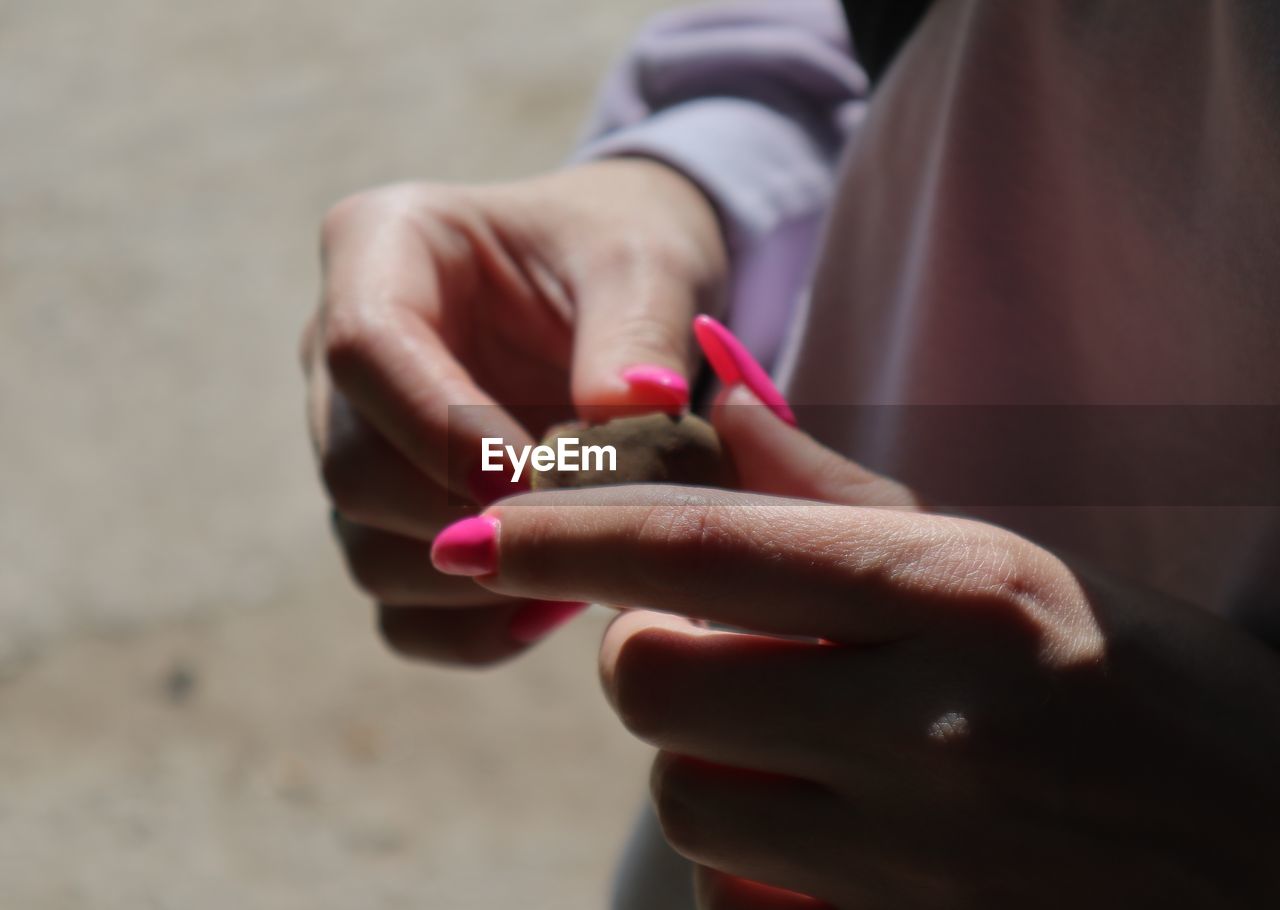 MIDSECTION OF WOMAN HOLDING CIGARETTE