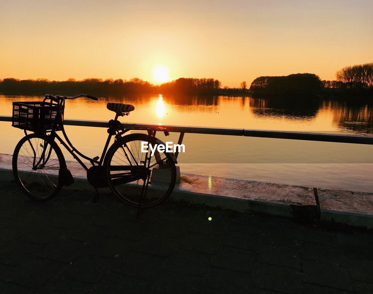 SILHOUETTE BICYCLE AGAINST LAKE DURING SUNSET