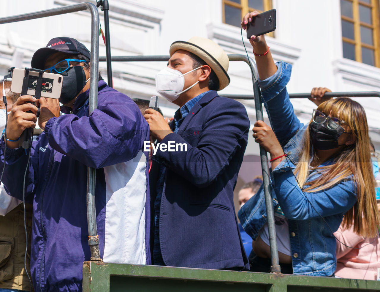 group of people, photographing, technology, adult, men, camera, smartphone, young adult, women, wireless technology, portable information device, activity, selfie, clothing, togetherness, communication, holding, standing, mobile phone, occupation, waist up, person, day, female, friendship, outdoors