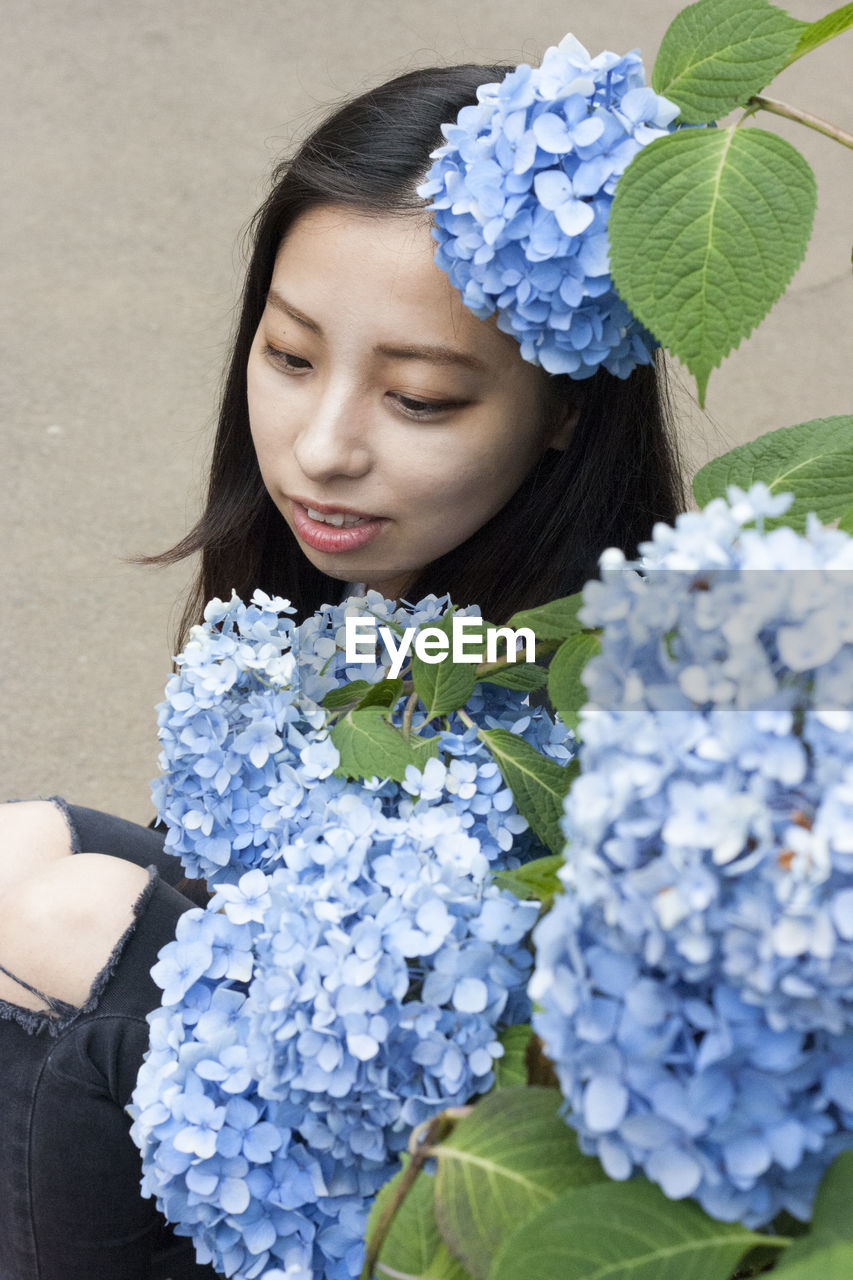 High angle view of woman sitting by hydrangea flowers