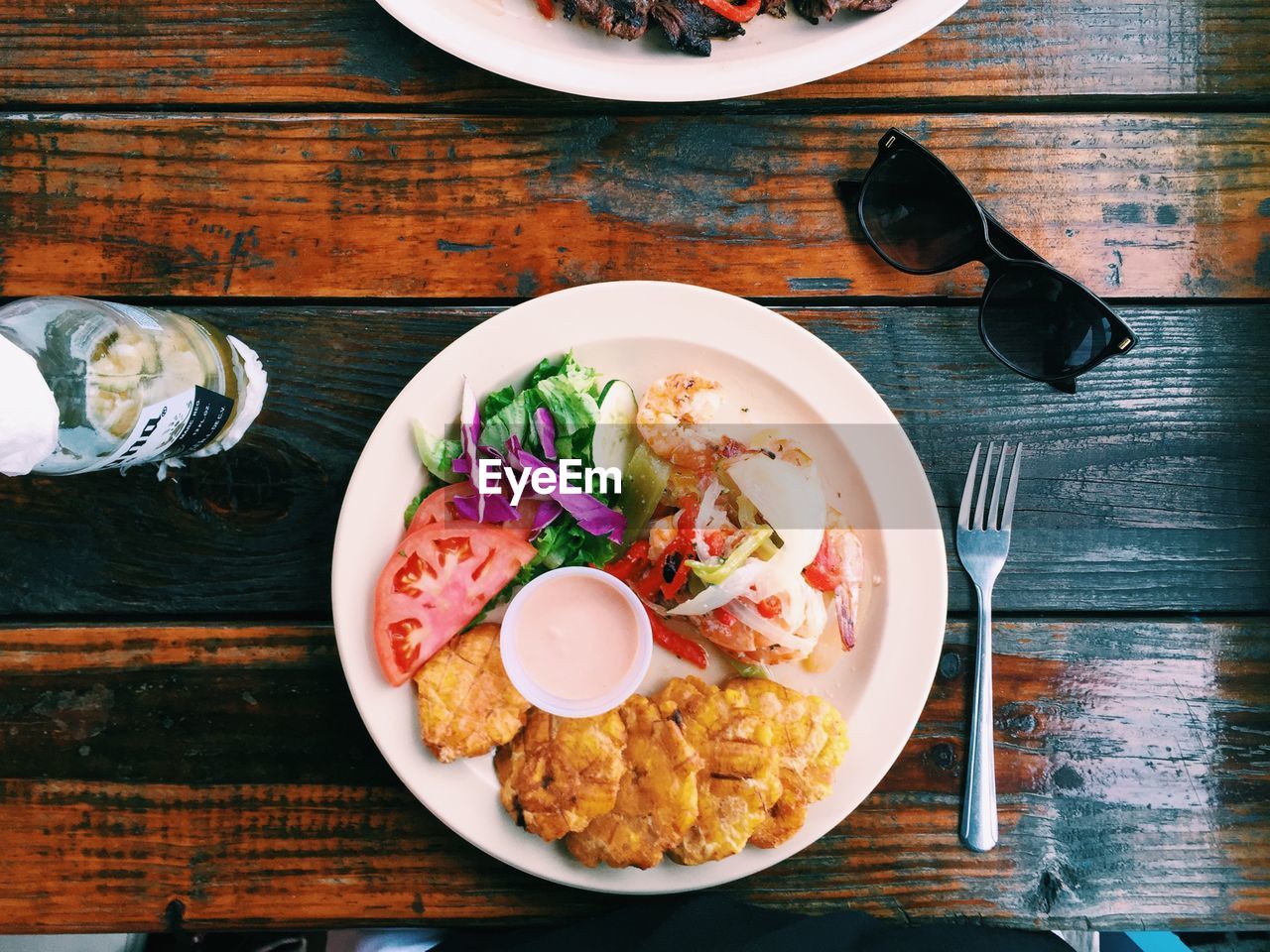 High angle view of fish with salad served in plate on table