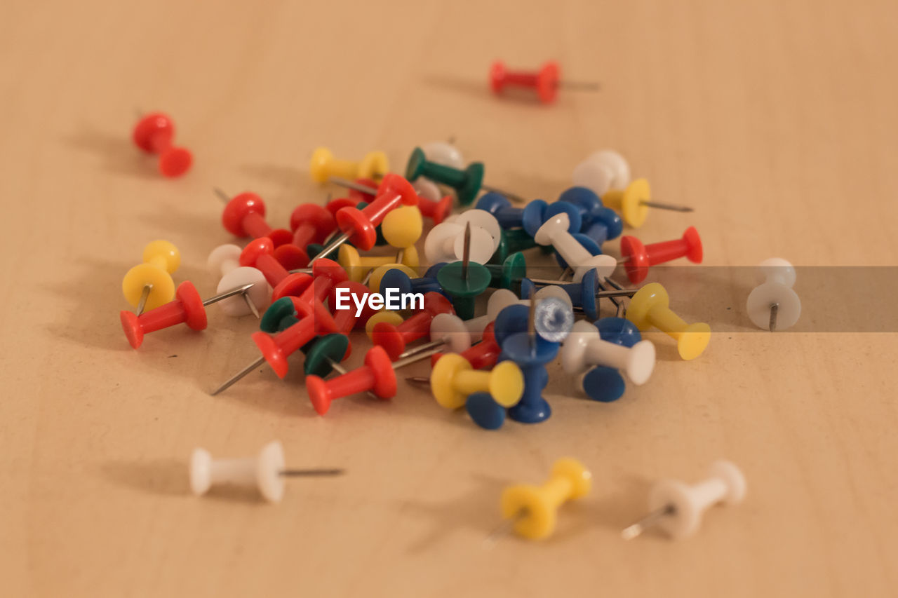 Close-up of multi colored thumbtack on table