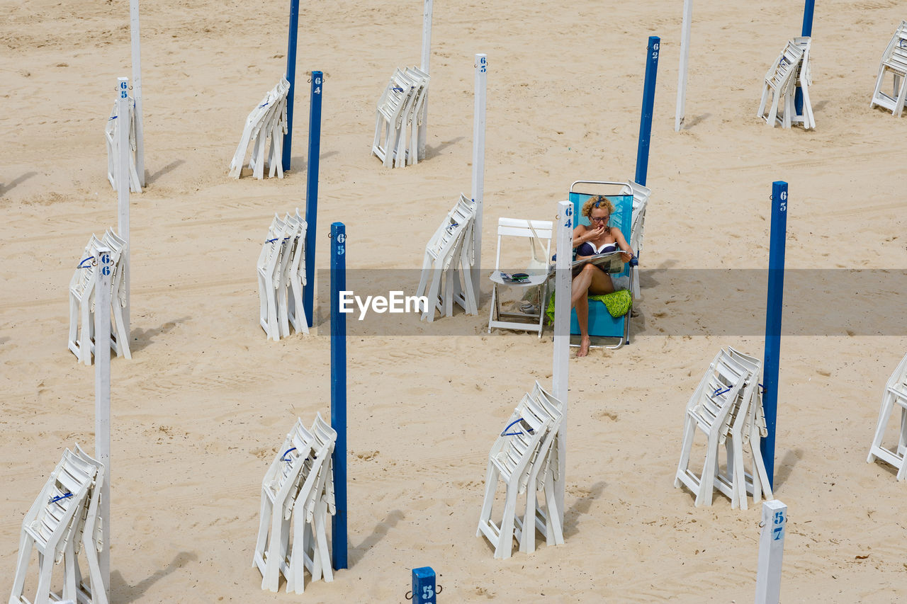 HIGH ANGLE VIEW OF SHOES HANGING ON BEACH