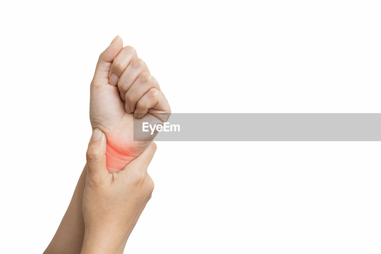CLOSE-UP OF PERSON HAND HOLDING HANDS OVER WHITE BACKGROUND