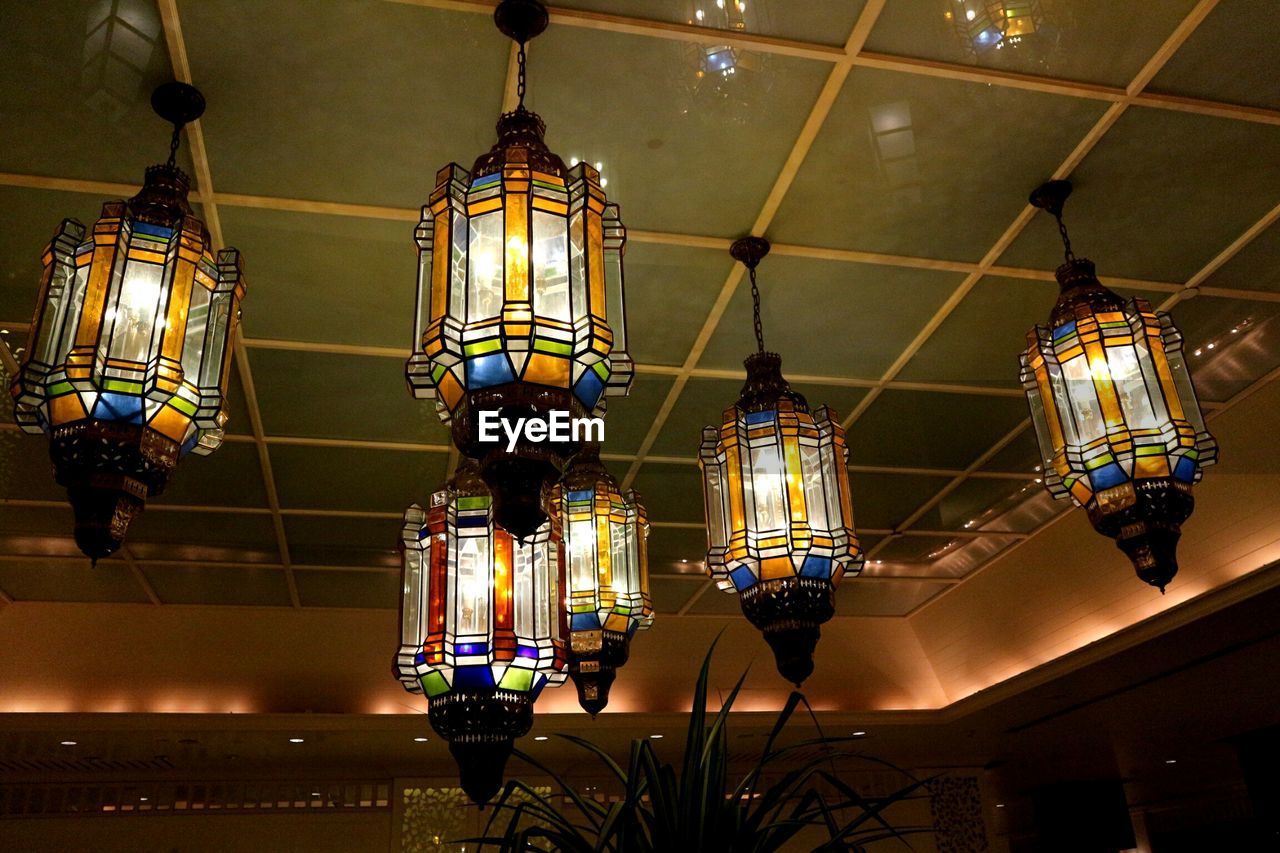 LOW ANGLE VIEW OF ILLUMINATED LANTERN HANGING ON CEILING