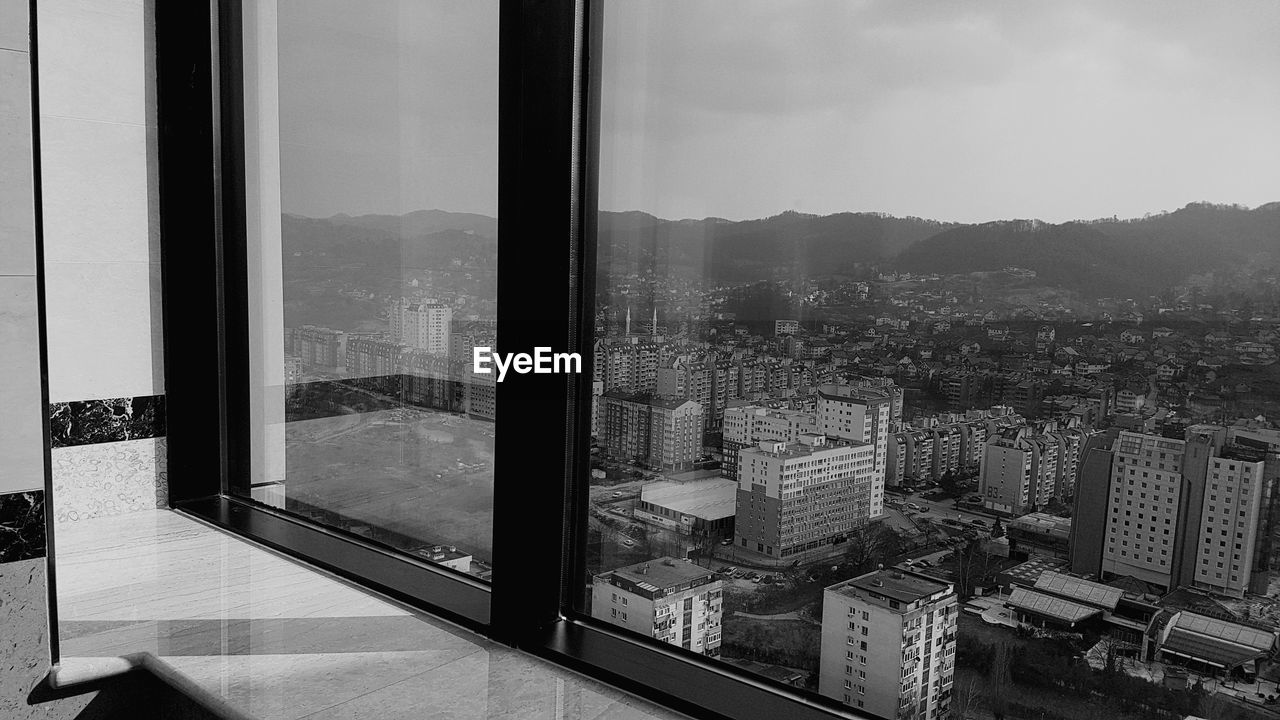 HIGH ANGLE VIEW OF CITYSCAPE AGAINST SKY