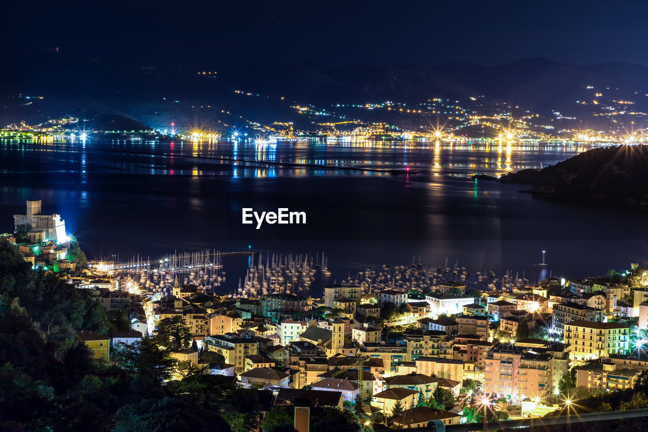 High angle view of illuminated buildings by river at night