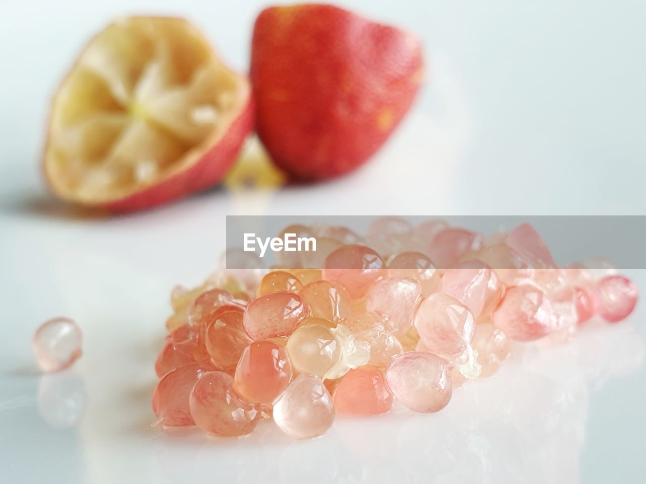 Close-up of caviar fruit grains  in plate with empty fruit skin in the background