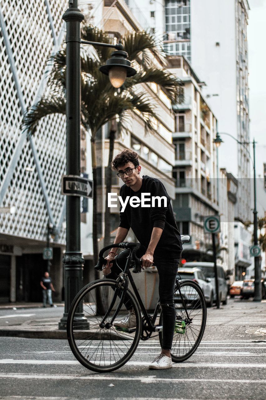 MAN RIDING BICYCLES ON STREET