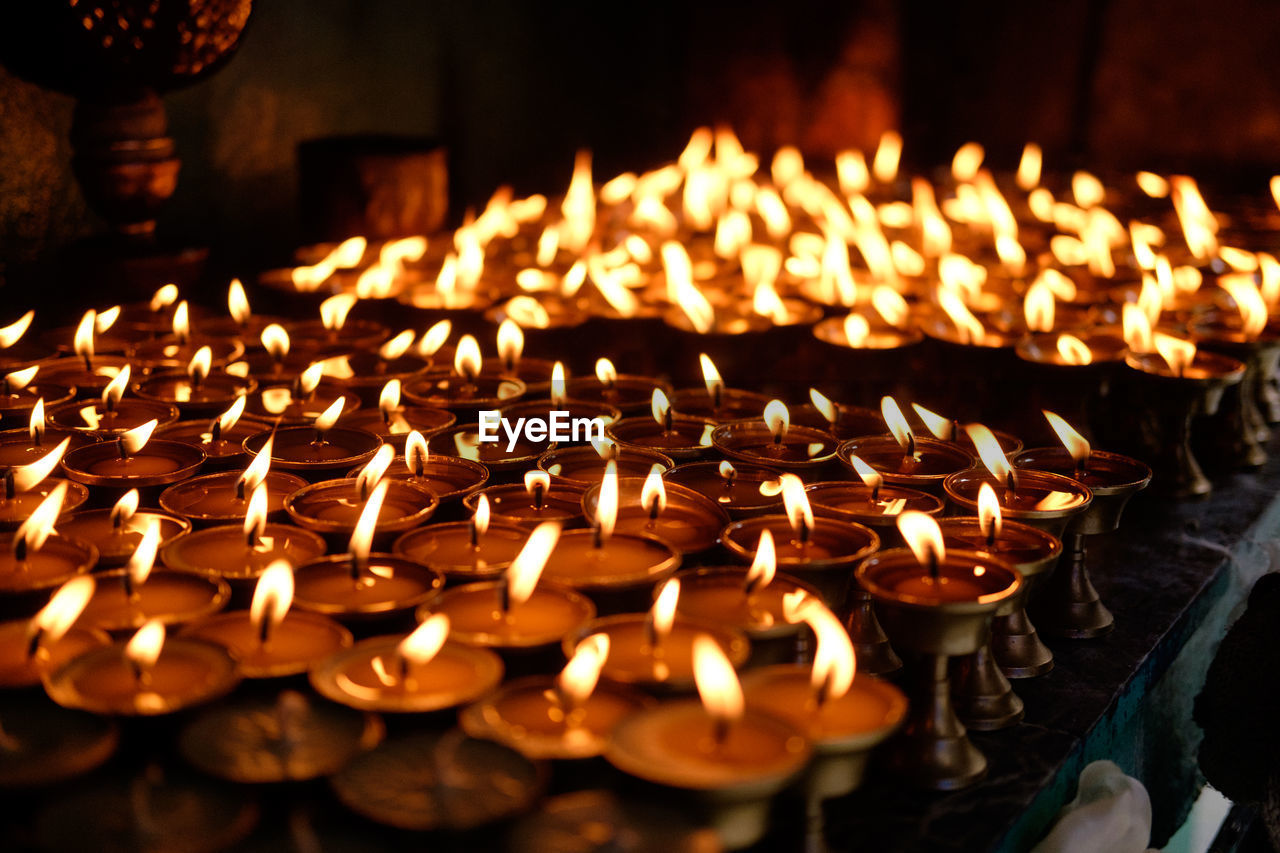 Close-up of lit candles in temple