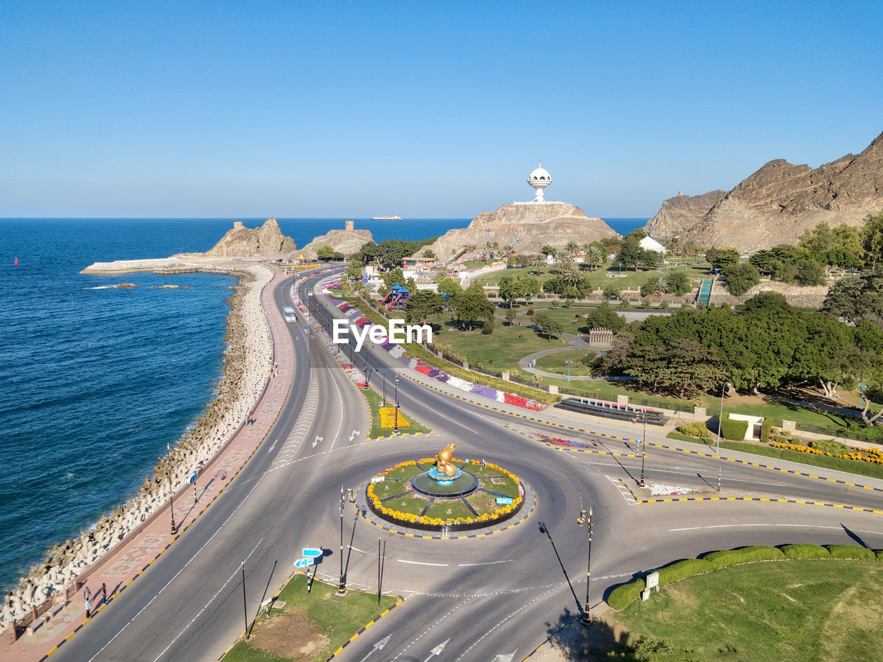 Aerial view of city by sea against clear sky