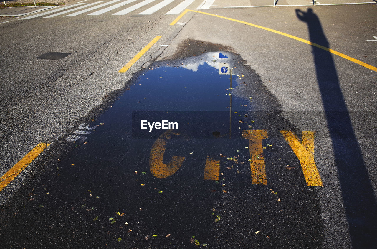 High angle view of puddle on road with city text