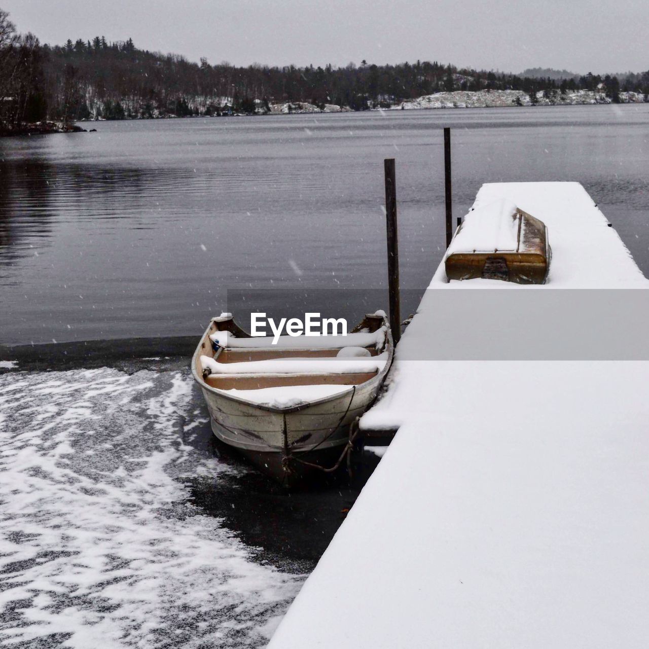 BOAT MOORED ON LAKE AGAINST SKY