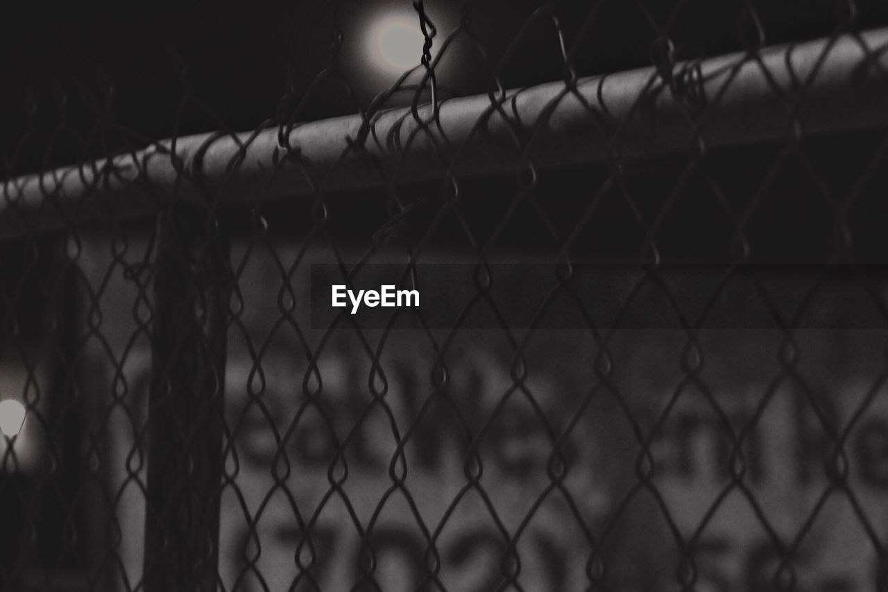 CLOSE-UP OF CHAINLINK FENCE AGAINST WIRE