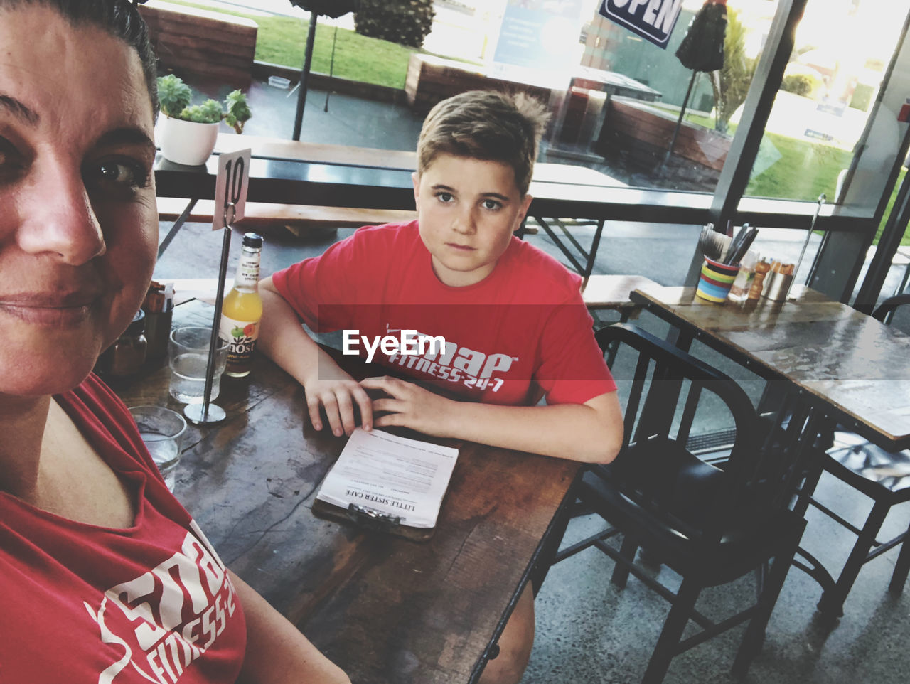 PORTRAIT OF BOY SITTING AT RESTAURANT