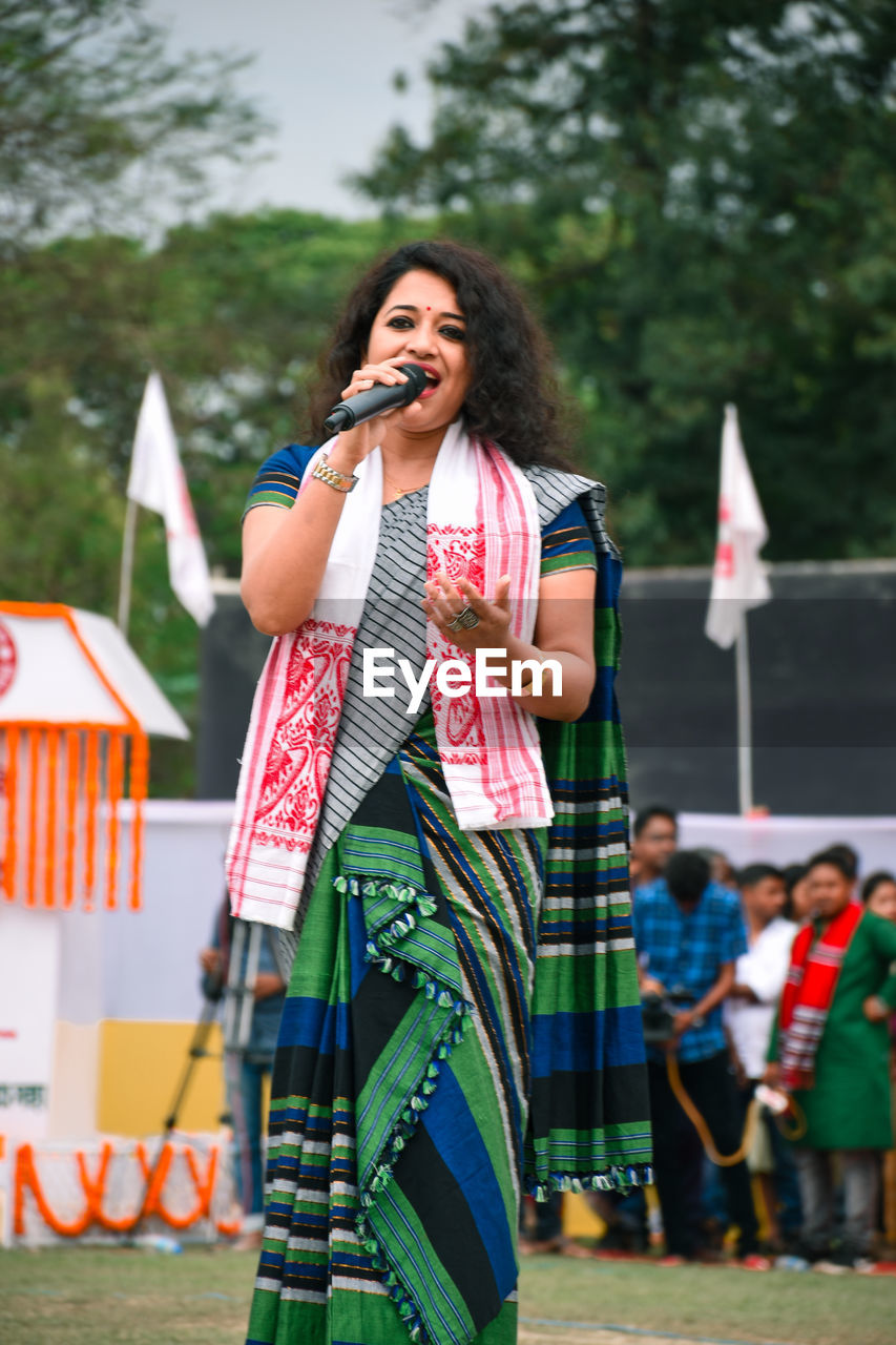 Young woman singing during festival