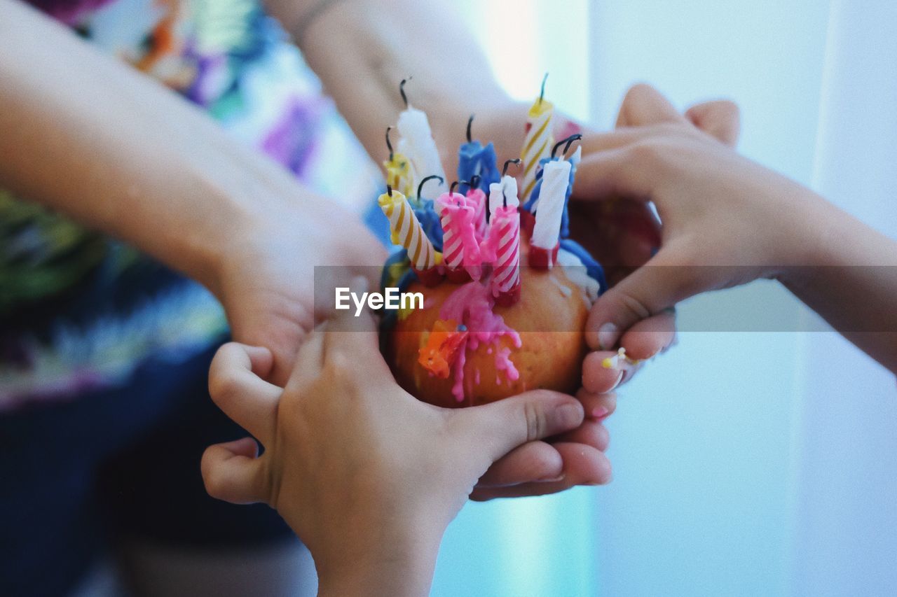 Cropped image of hands holding candles