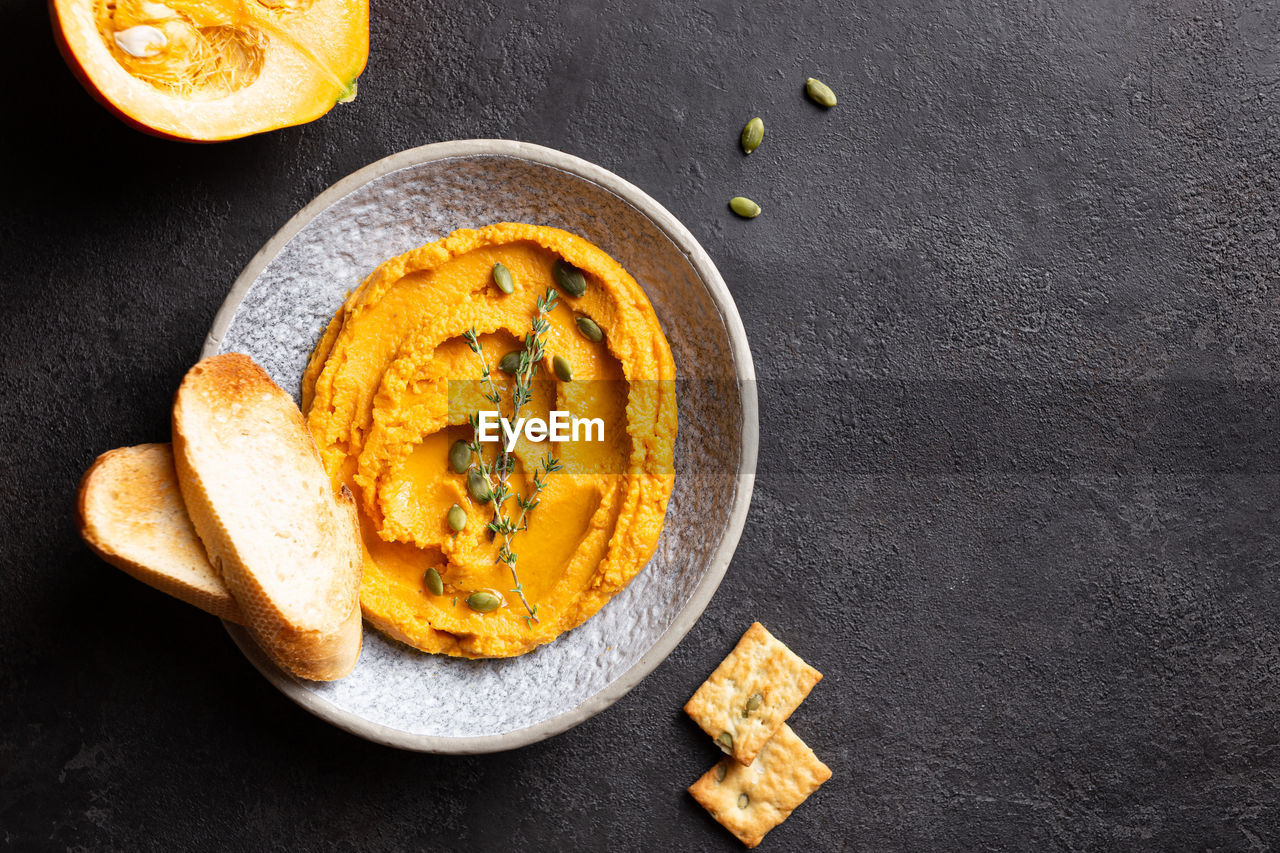 Pumpkin hummus decorated with greens and toasted bread