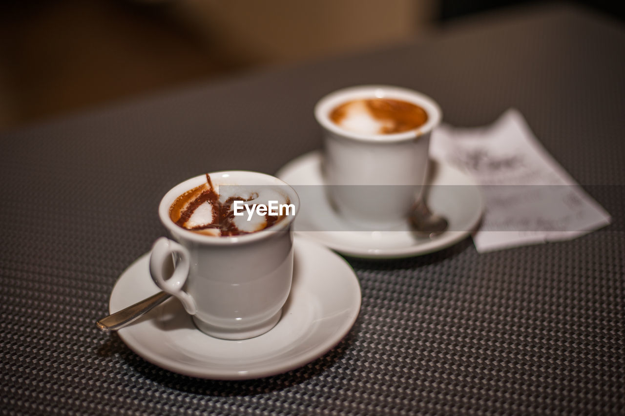 Close-up of coffee cups on table