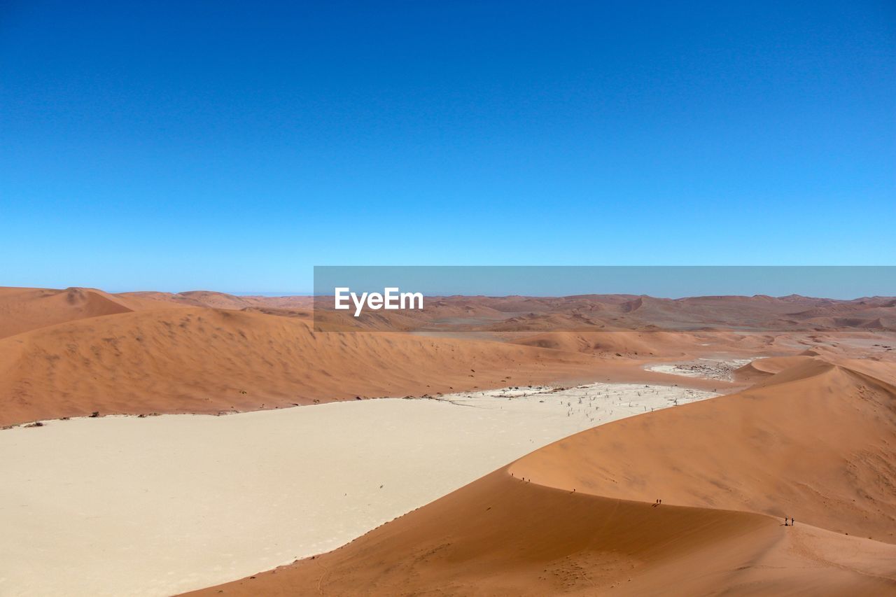 Scenic view of desert against clear blue sky