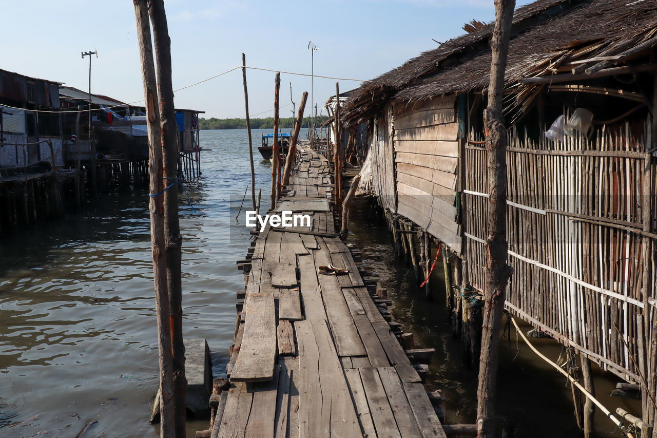 PANORAMIC VIEW OF WOODEN PIER OVER CANAL AMIDST BUILDINGS